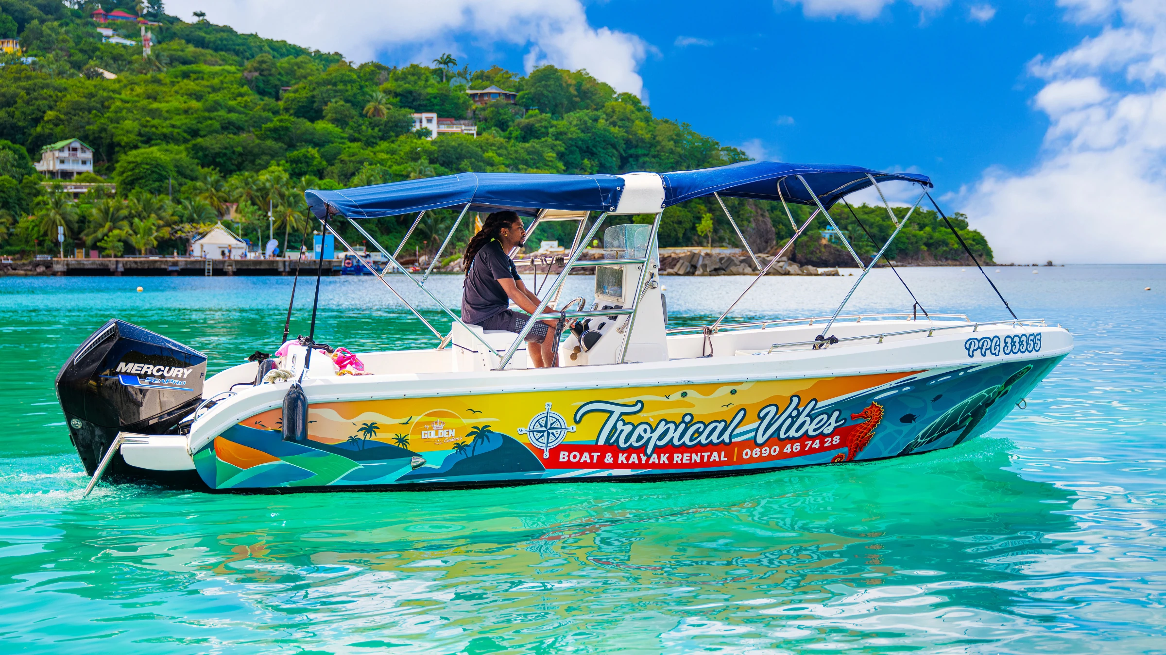 Bateau Tropical Vibes ancré dans une crique turquoise au large de Deshaies, Guadeloupe